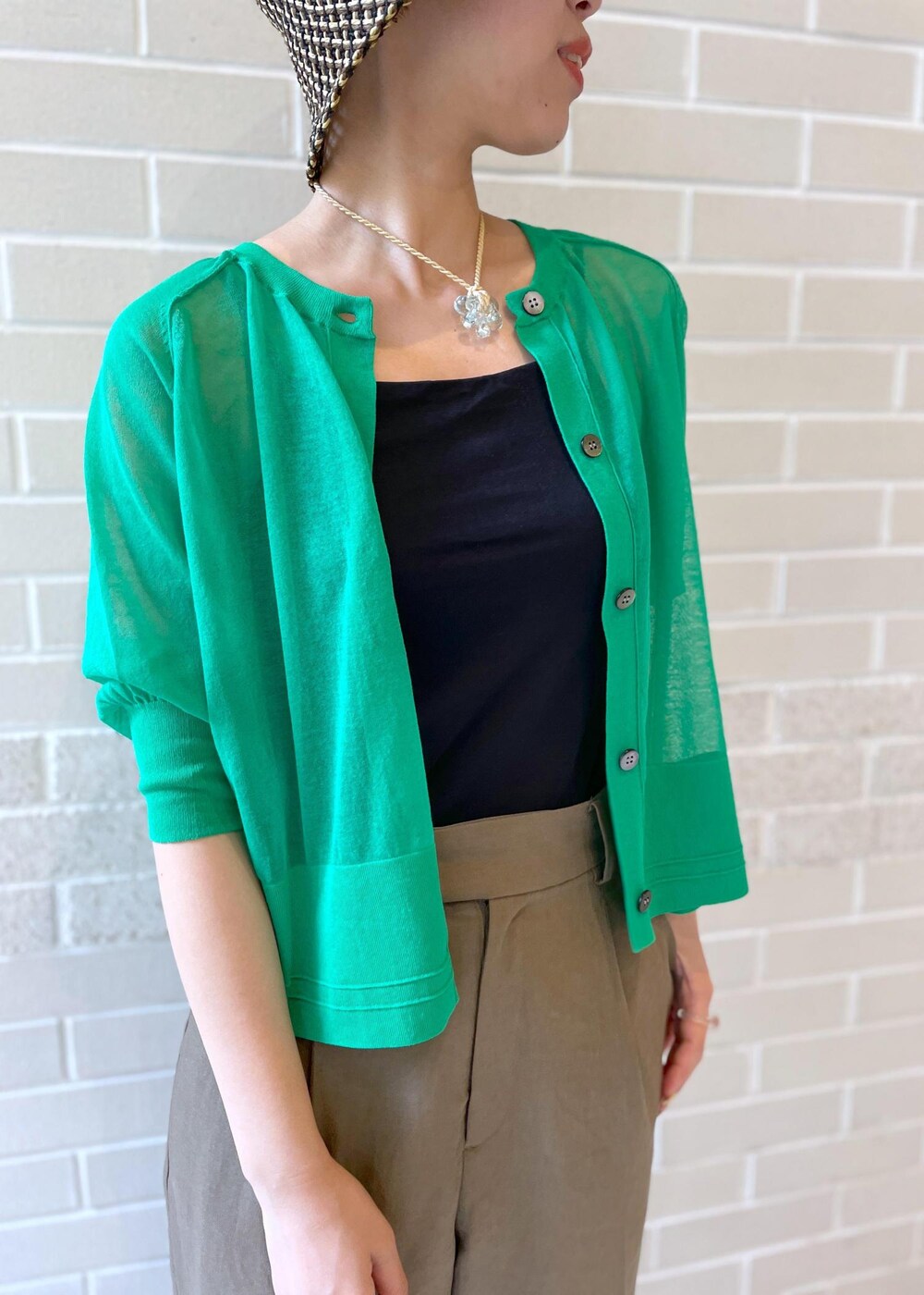 ブラウン系のその他パンツ、グリーン系のカーディガン/ボレロ、ブラック系のハットを着用したレディースの春コーディネートの6枚目の写真