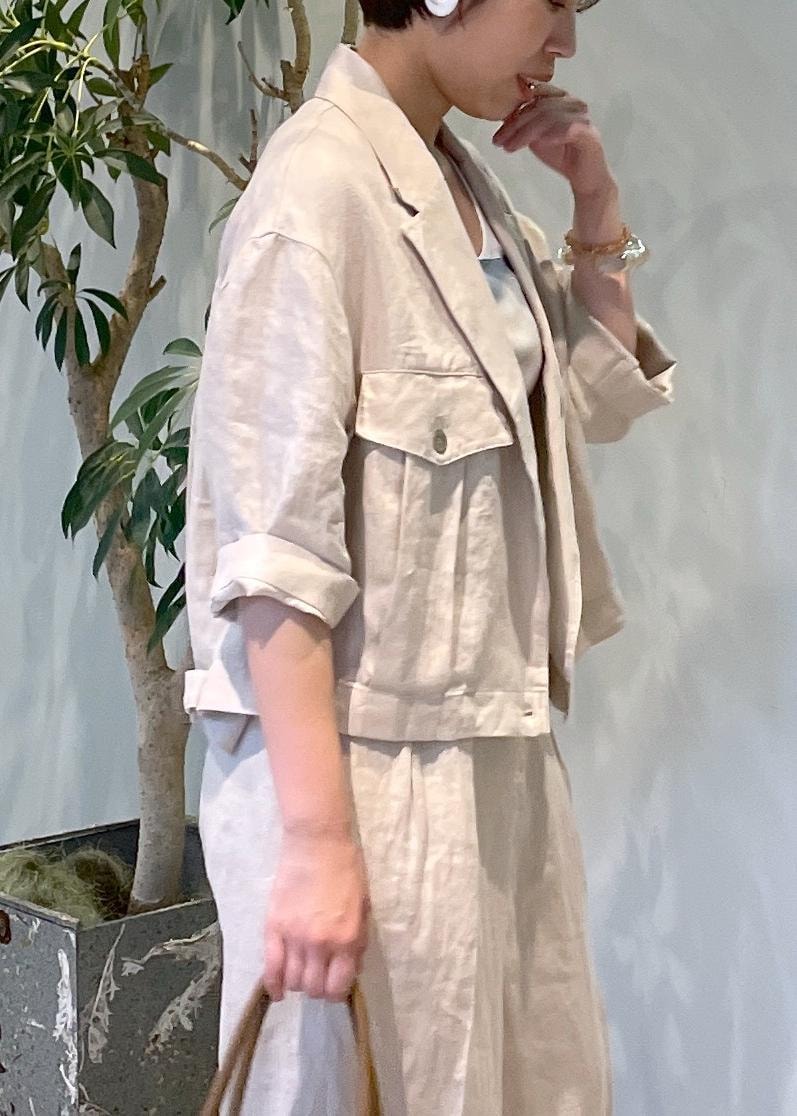 ブラウン系のボストンバッグ、ホワイト系のサンダル、ベージュ系のブルゾンを着用したレディースの夏コーディネートの6枚目の写真