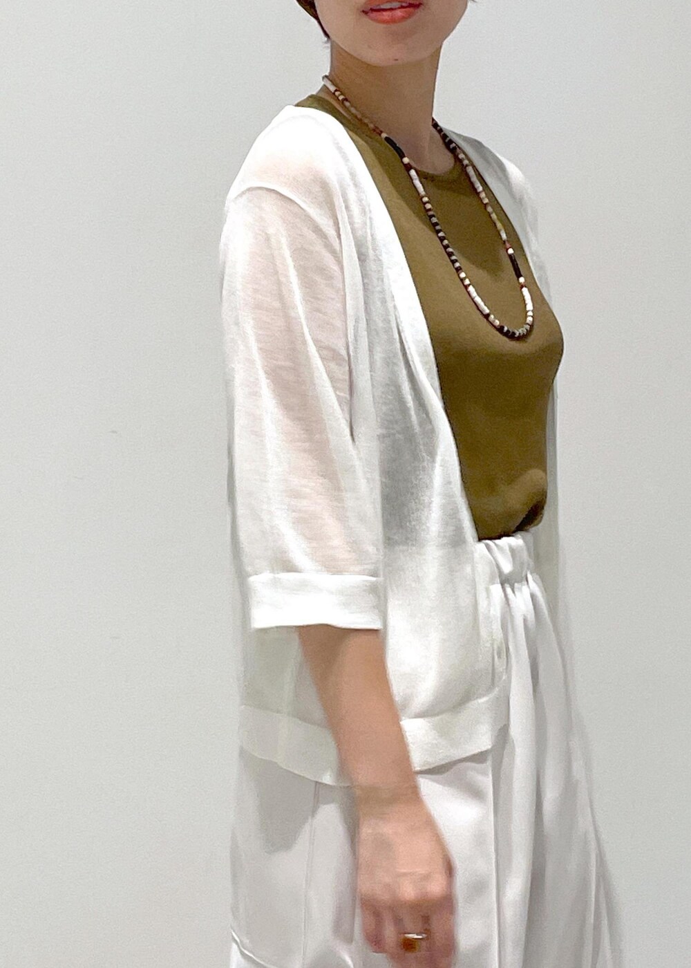 ホワイト系のタンクトップ、ホワイト系のカーディガン/ボレロを着用したレディースの夏コーディネートの7枚目の写真