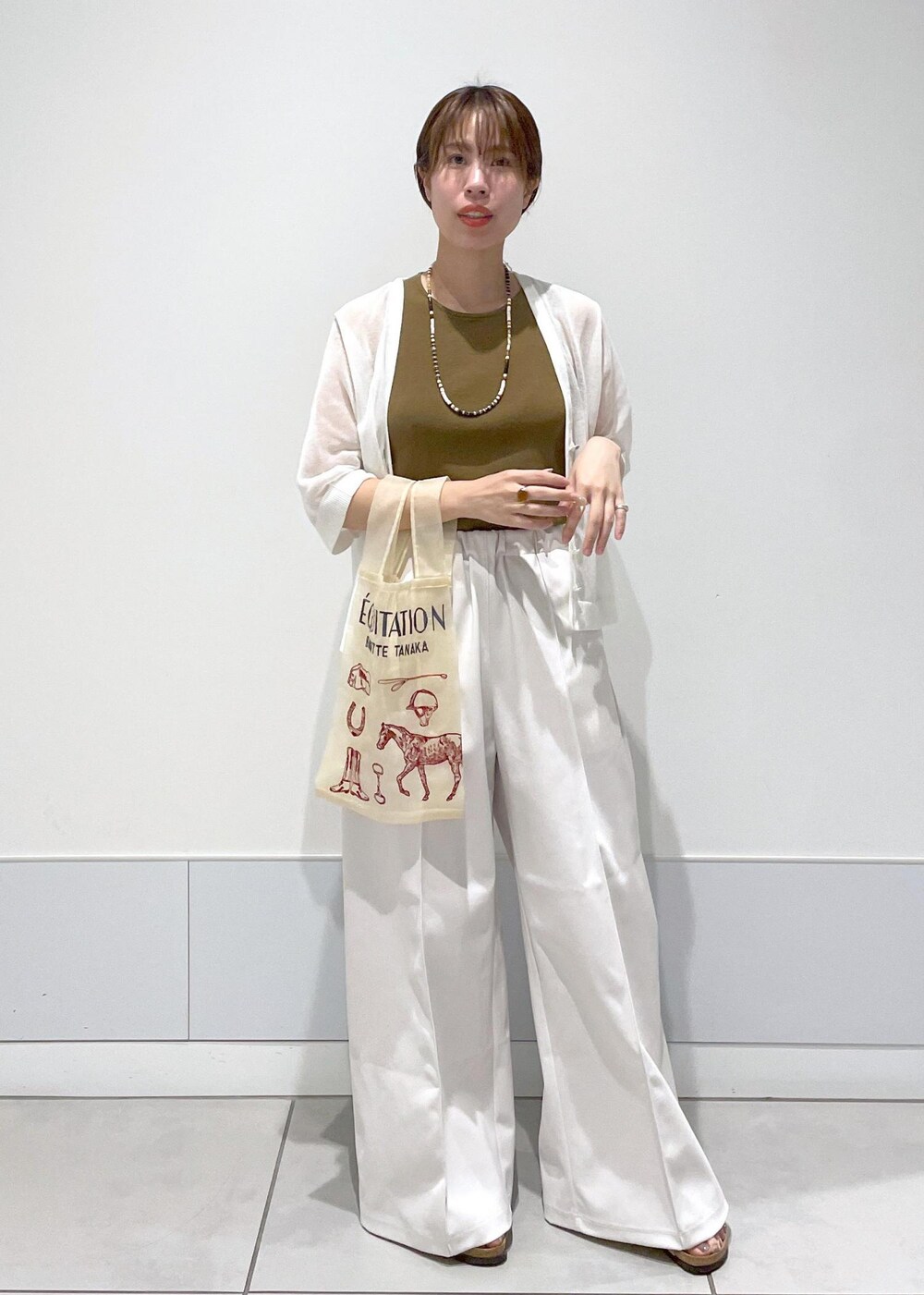 ホワイト系のタンクトップ、ホワイト系のカーディガン/ボレロを着用したレディースの夏コーディネートの4枚目の写真