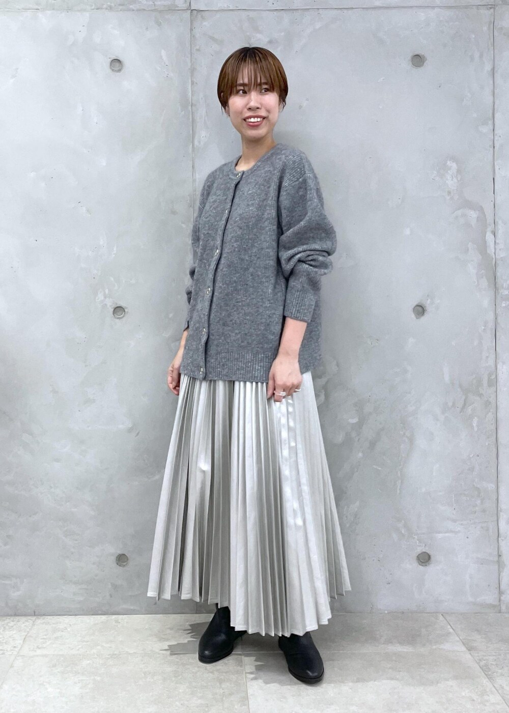 シルバー系のスカート、グレー系のカーディガン/ボレロ、シルバー系のスカートを着用したレディースの夏コーディネートの2枚目の写真