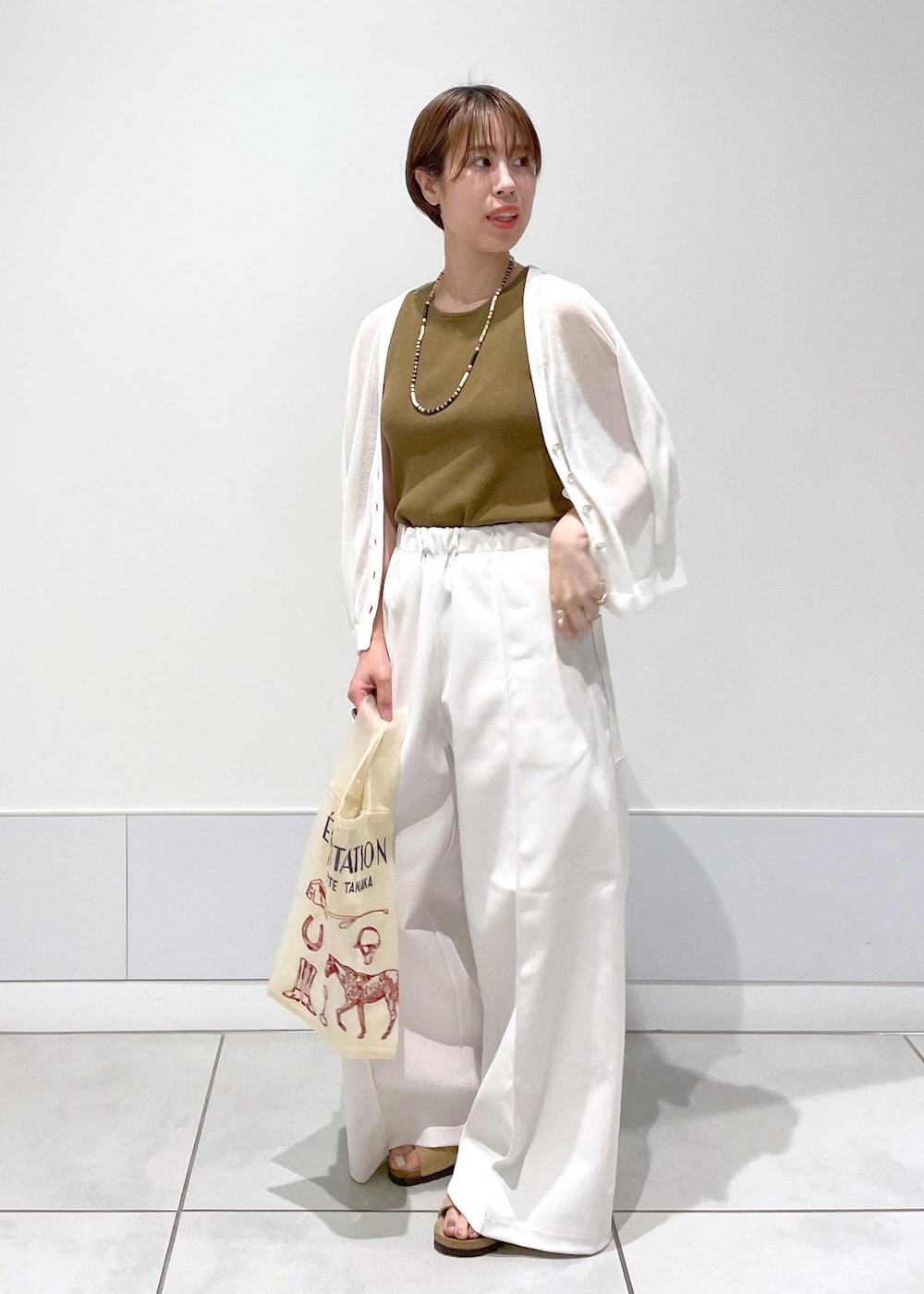 ホワイト系のタンクトップ、ホワイト系のカーディガン/ボレロを着用したレディースの夏コーディネートの3枚目の写真