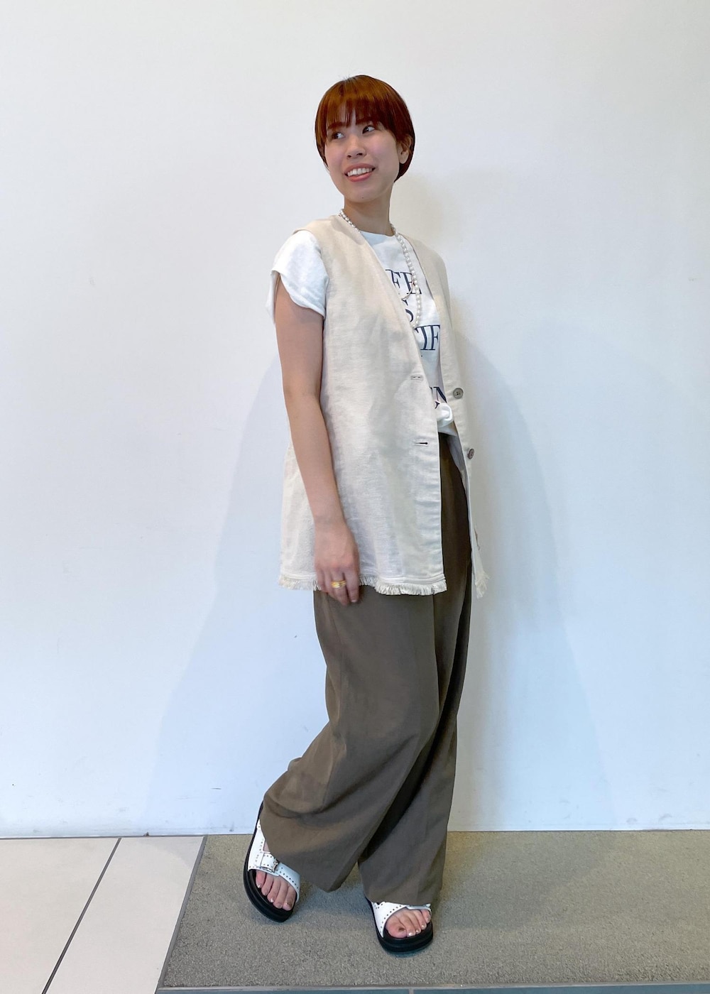 ホワイト系のTシャツ/カットソー、ホワイト系のサンダル、ブラウン系のその他パンツを着用したレディースの夏コーディネートの2枚目の写真
