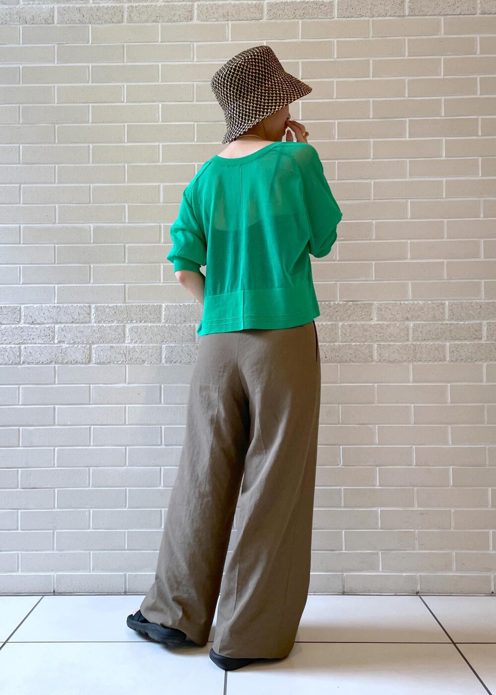 ブラウン系のその他パンツ、グリーン系のカーディガン/ボレロ、ブラック系のハットを着用したレディースの春コーディネートの4枚目の写真