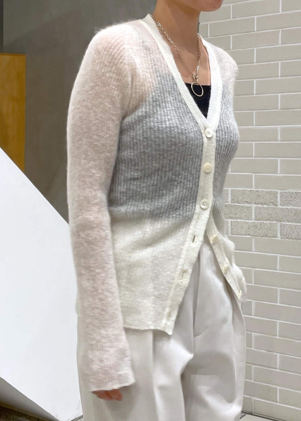 イエロー系のチェスターコート、ホワイト系のその他パンツ、ホワイト系のカーディガン/ボレロを着用したレディースの冬コーディネートの8枚目の写真