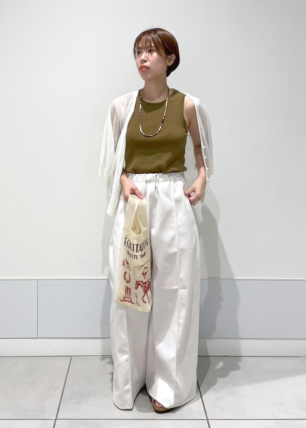 ホワイト系のタンクトップ、ホワイト系のカーディガン/ボレロを着用したレディースの夏コーディネートの2枚目の写真