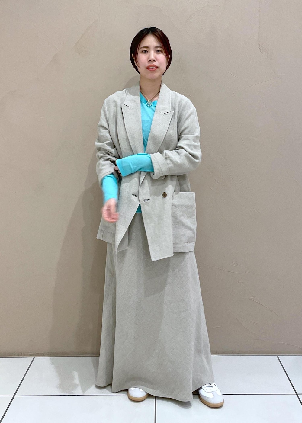 ベージュ系のテーラードジャケット、ベージュ系のスカートを着用したレディースの冬コーディネートの2枚目の写真