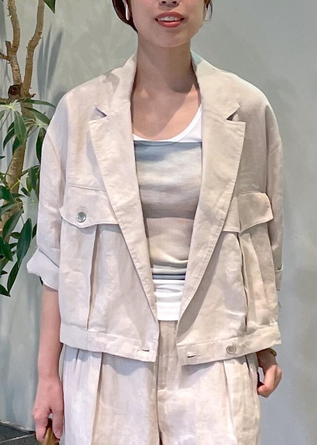 ブラウン系のボストンバッグ、ホワイト系のサンダル、ベージュ系のブルゾンを着用したレディースの夏コーディネートの5枚目の写真