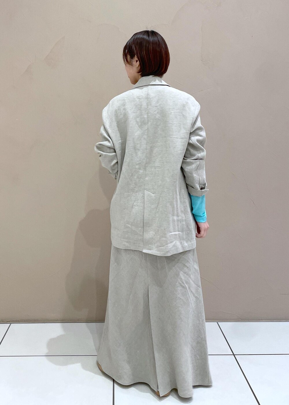 ベージュ系のテーラードジャケット、ベージュ系のスカートを着用したレディースの冬コーディネートの5枚目の写真