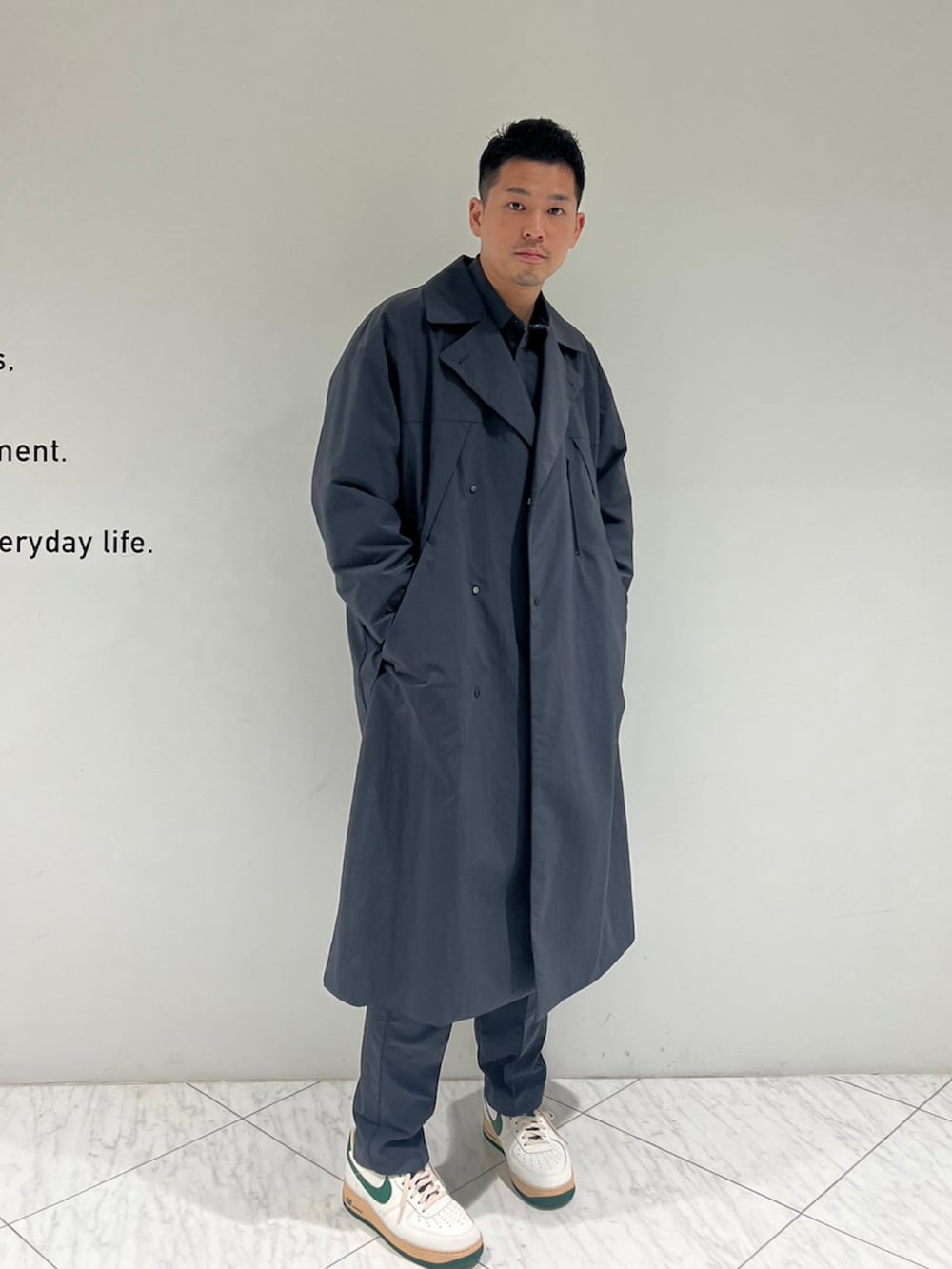 グレー系のチェスターコート、グレー系のスラックスを着用したメンズの秋コーディネートの2枚目の写真