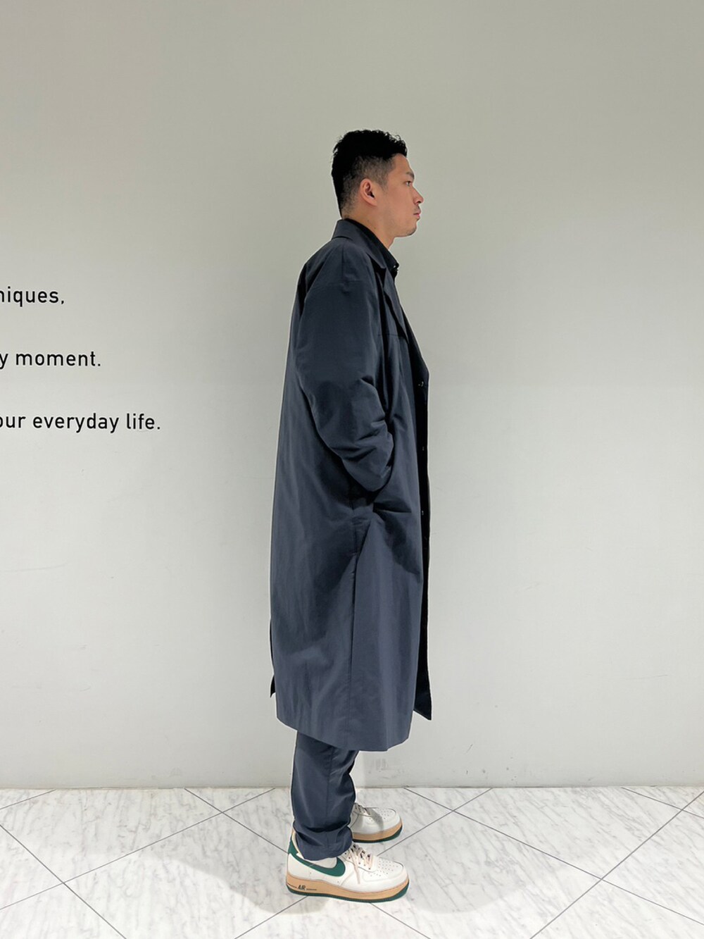 グレー系のチェスターコート、グレー系のスラックスを着用したメンズの秋コーディネートの3枚目の写真