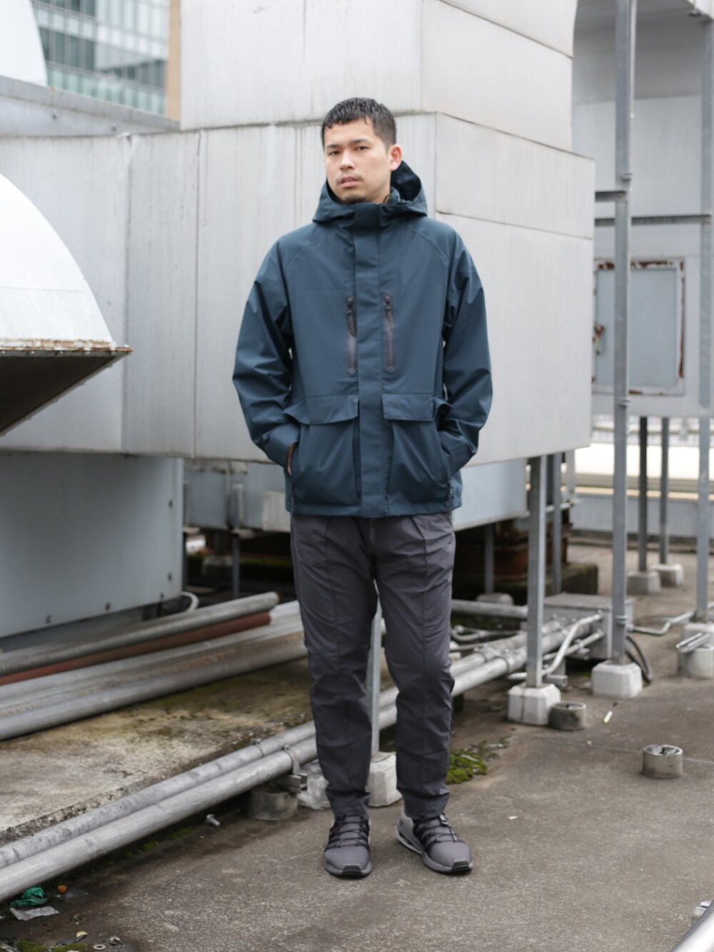 グリーン系のブルゾン、グレー系のスラックスを着用したメンズの秋コーディネートの5枚目の写真