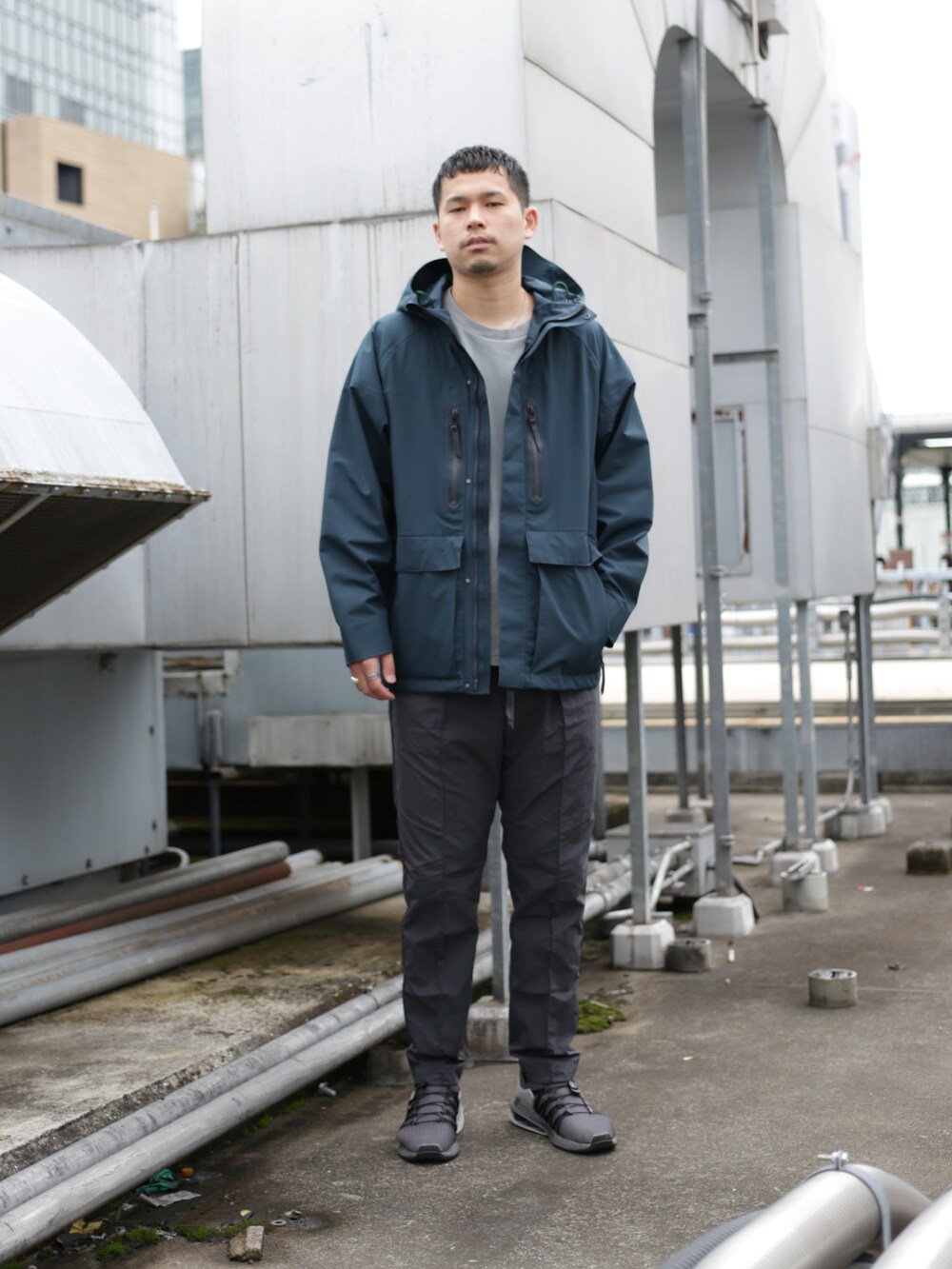 グリーン系のブルゾン、グレー系のスラックスを着用したメンズの秋コーディネートの2枚目の写真