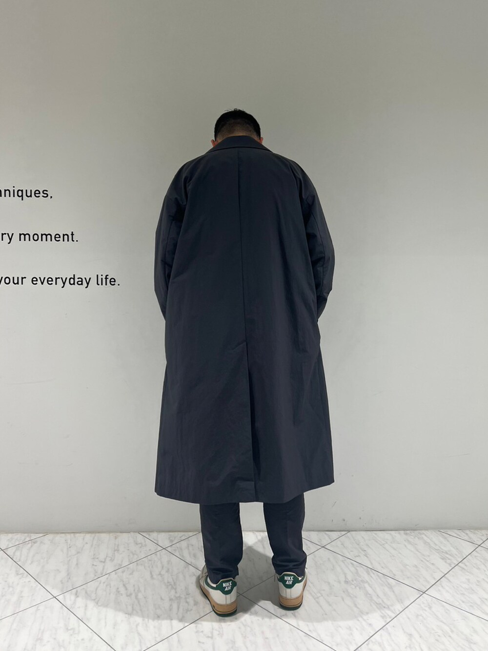 グレー系のチェスターコート、グレー系のスラックスを着用したメンズの秋コーディネートの4枚目の写真