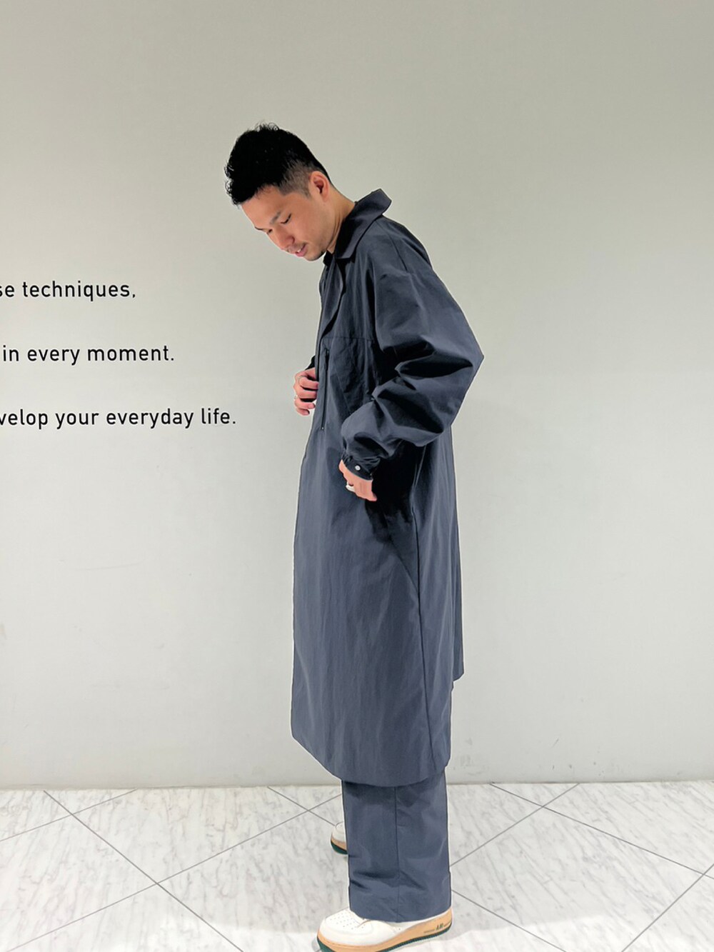 グレー系のチェスターコート、グレー系のスラックスを着用したメンズの秋コーディネートの3枚目の写真