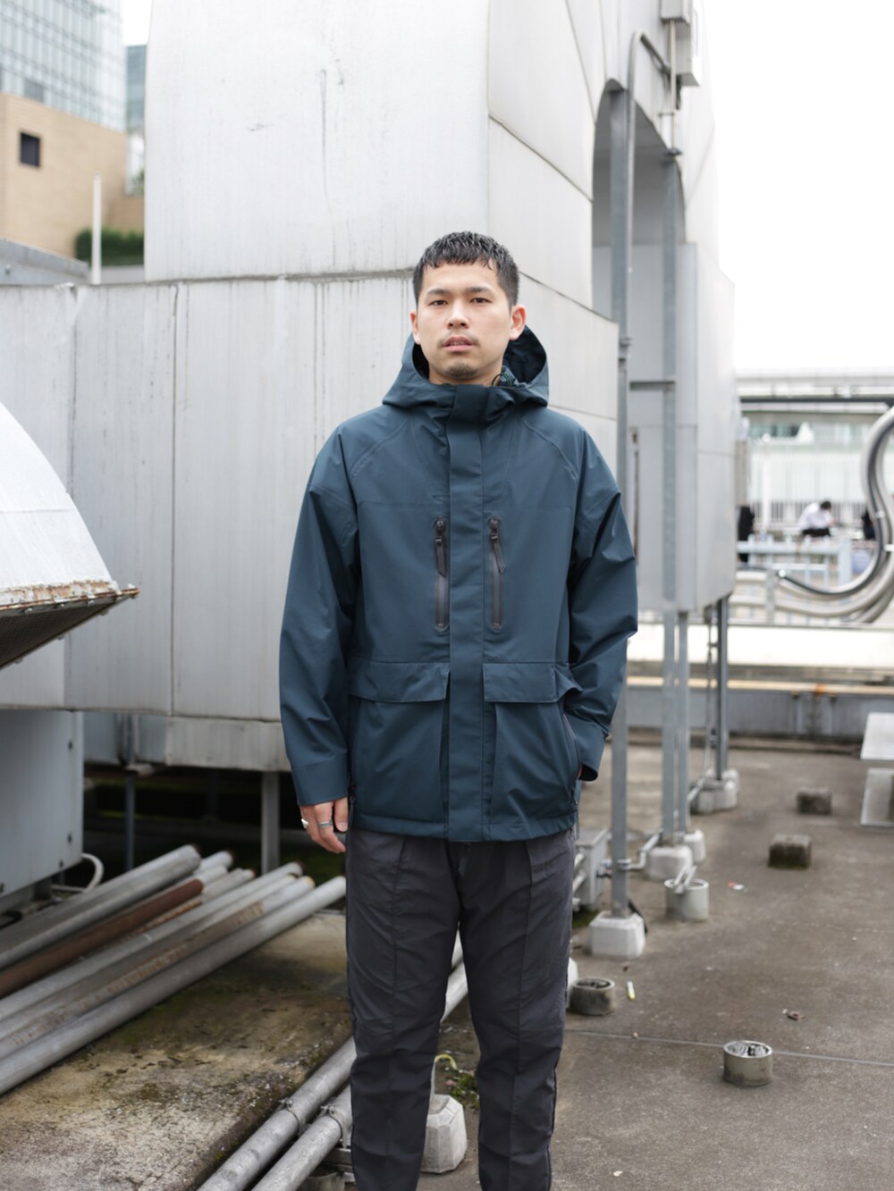 グリーン系のブルゾン、グレー系のスラックスを着用したメンズの秋コーディネートの3枚目の写真