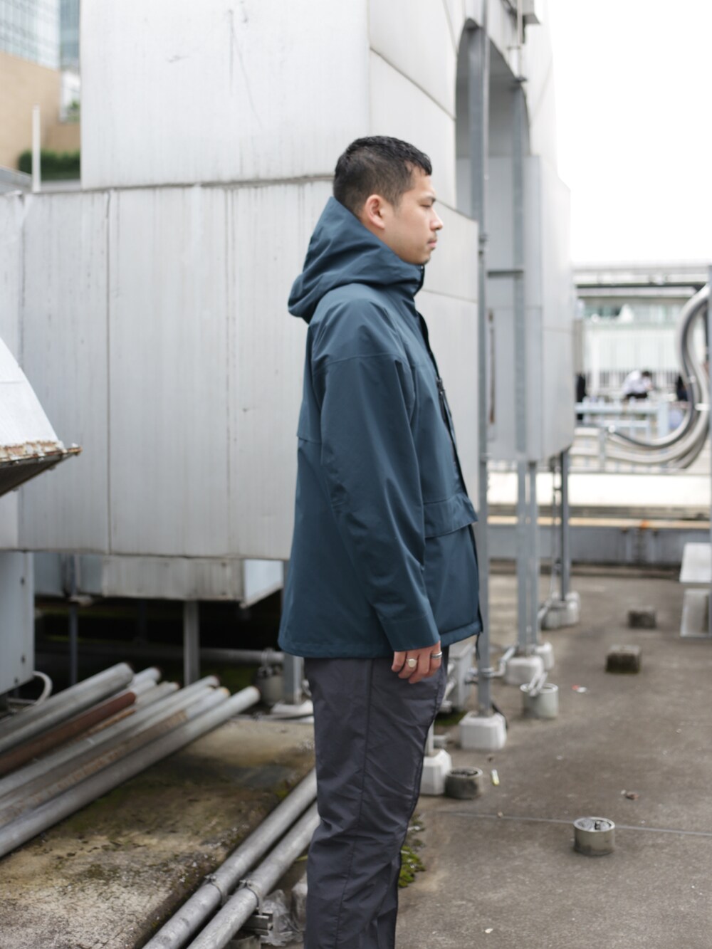 グリーン系のブルゾン、グレー系のスラックスを着用したメンズの秋コーディネートの4枚目の写真