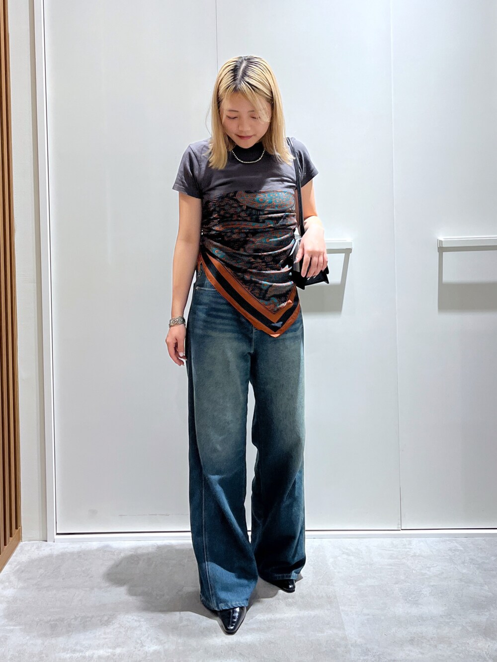 グレー系のTシャツ/カットソー、ブルー系のデニムパンツ、ブラック系のショルダーバッグを着用したレディースの秋コーディネートの3枚目の写真