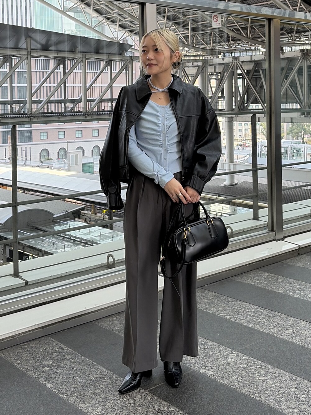 ブルー系のTシャツ/カットソー、グレー系のスラックス、ブラック系のハンドバッグを着用したレディースの冬コーディネートの3枚目の写真