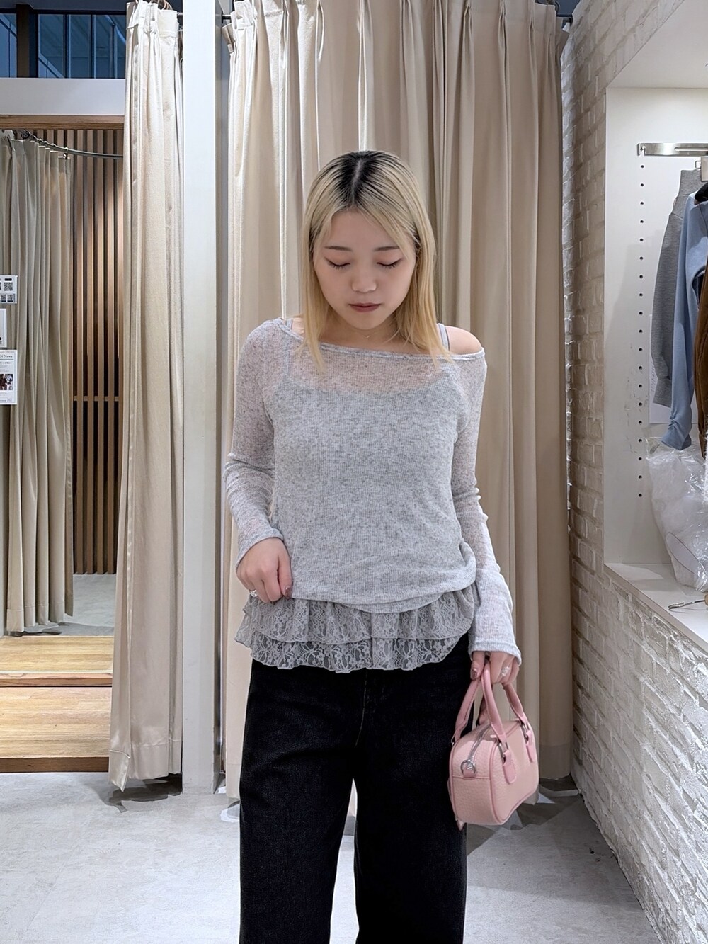 ピンク系のボストンバッグ、グレー系のTシャツ/カットソー、ブラック系のデニムパンツを着用したレディースの冬コーディネートの3枚目の写真