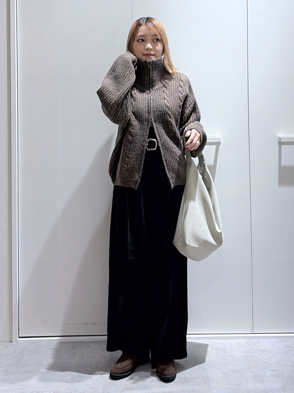 グレー系のスラックス、ブラウン系のブルゾン、グレー系のショルダーバッグを着用したレディースの秋コーディネートの2枚目の写真