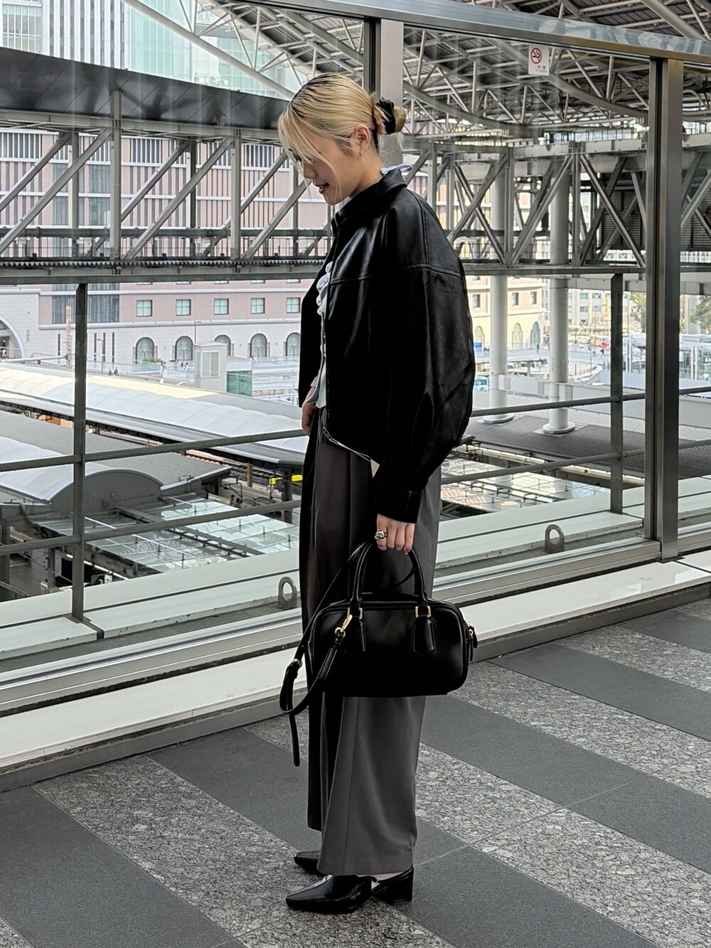 ブルー系のTシャツ/カットソー、グレー系のスラックス、ブラック系のハンドバッグを着用したレディースの冬コーディネートの4枚目の写真