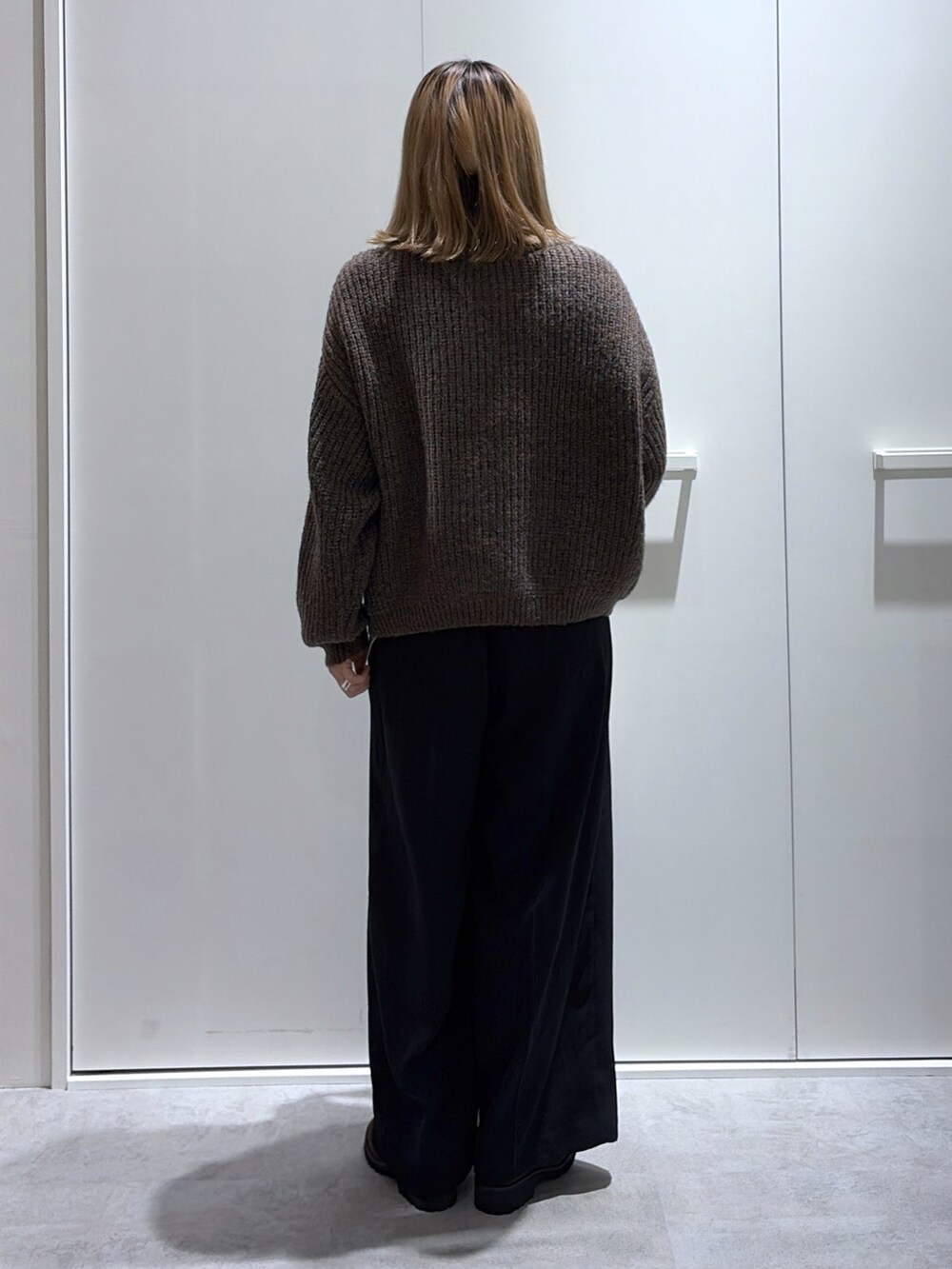 グレー系のスラックス、ブラウン系のブルゾン、グレー系のショルダーバッグを着用したレディースの秋コーディネートの3枚目の写真