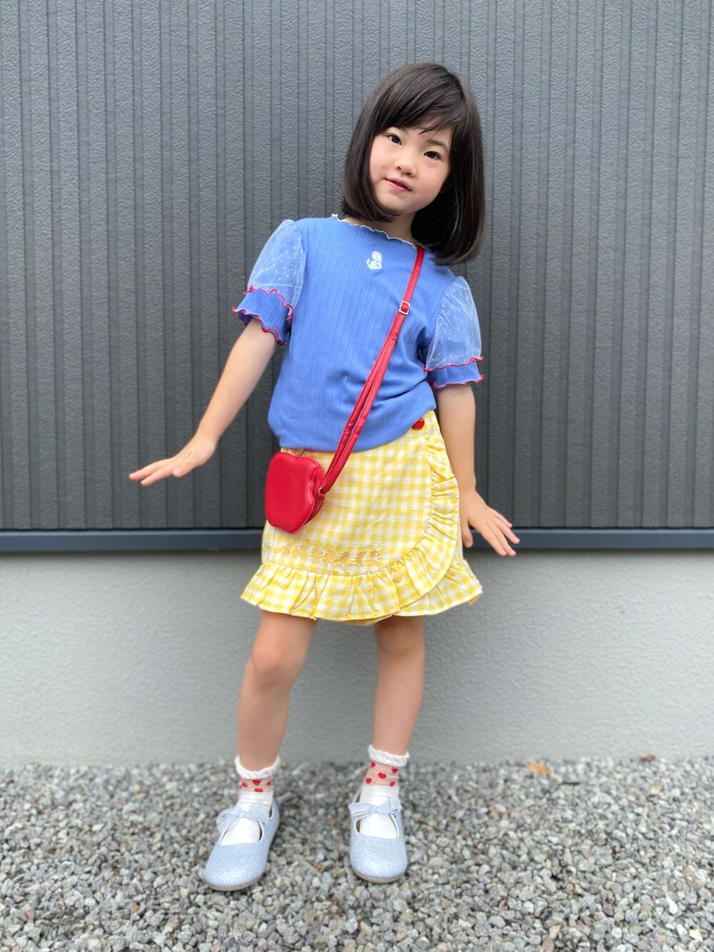 ブルー系のTシャツ/カットソー、イエロー系のパンツ、シルバー系のパンプスを着用したキッズの夏コーディネートの2枚目の写真