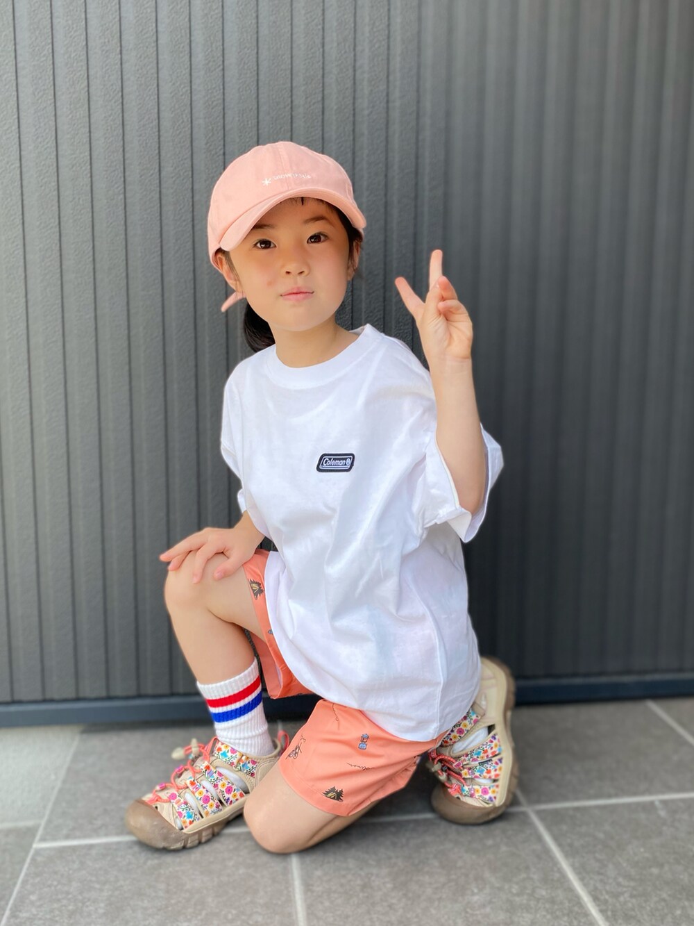 ホワイト系のTシャツ/カットソー、オレンジ系のパンツ、ベージュ系のサンダルを着用したキッズの夏コーディネートの2枚目の写真