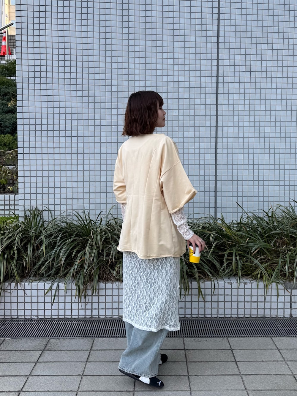 ホワイト系のワンピース、イエロー系のTシャツ/カットソー、ブルー系のデニムパンツを着用したレディースの春コーディネートの4枚目の写真