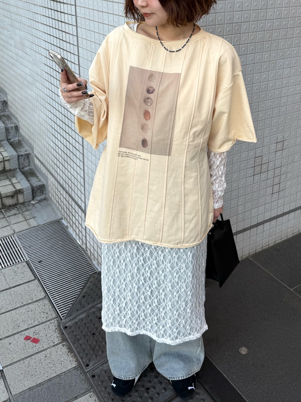 ホワイト系のワンピース、イエロー系のTシャツ/カットソー、ブルー系のデニムパンツを着用したレディースの春コーディネートの3枚目の写真