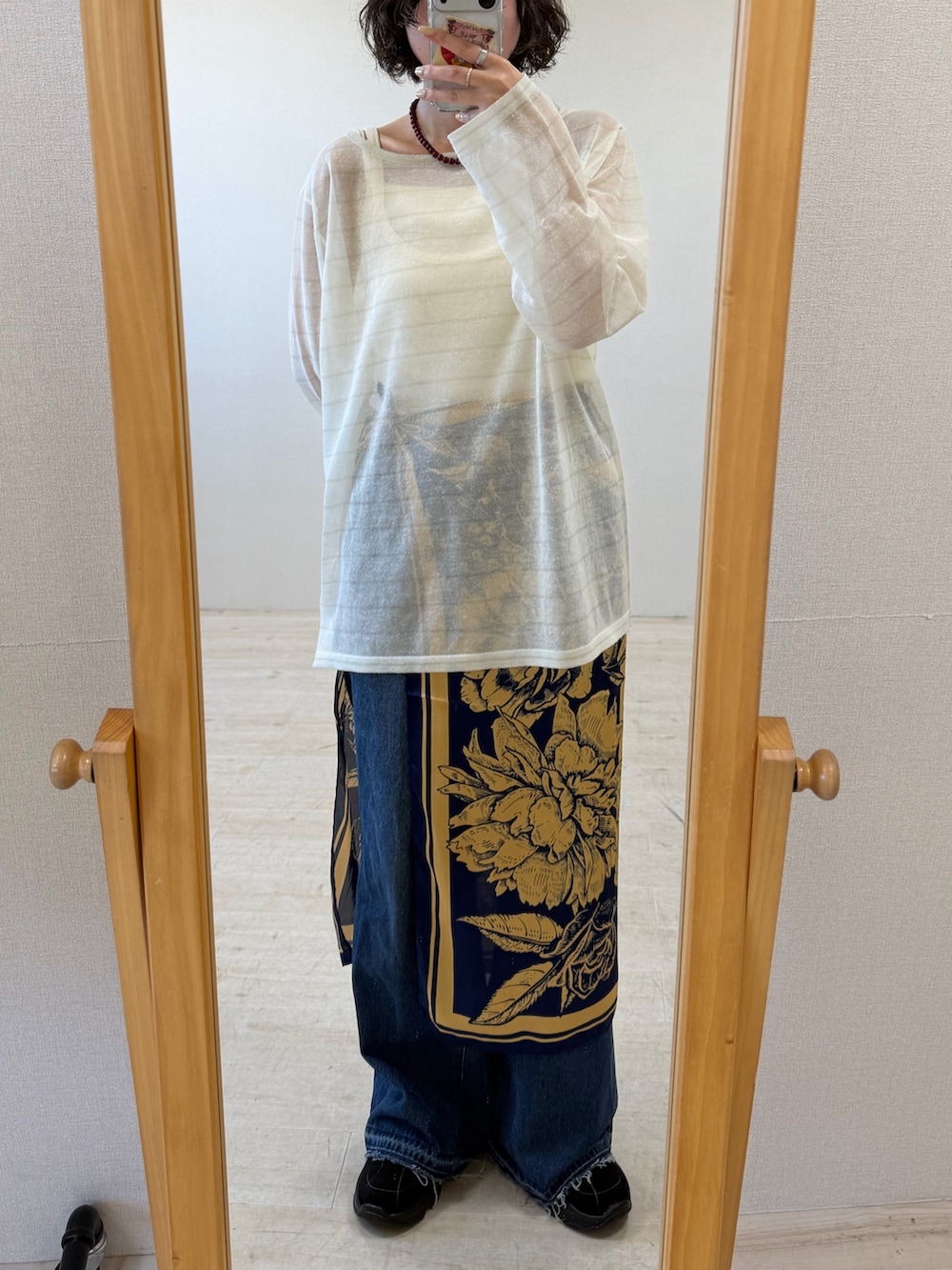 ホワイト系のニット/セーター、ブルー系のデニムパンツ、ブラック系のスニーカーを着用したレディースの秋コーディネートの2枚目の写真