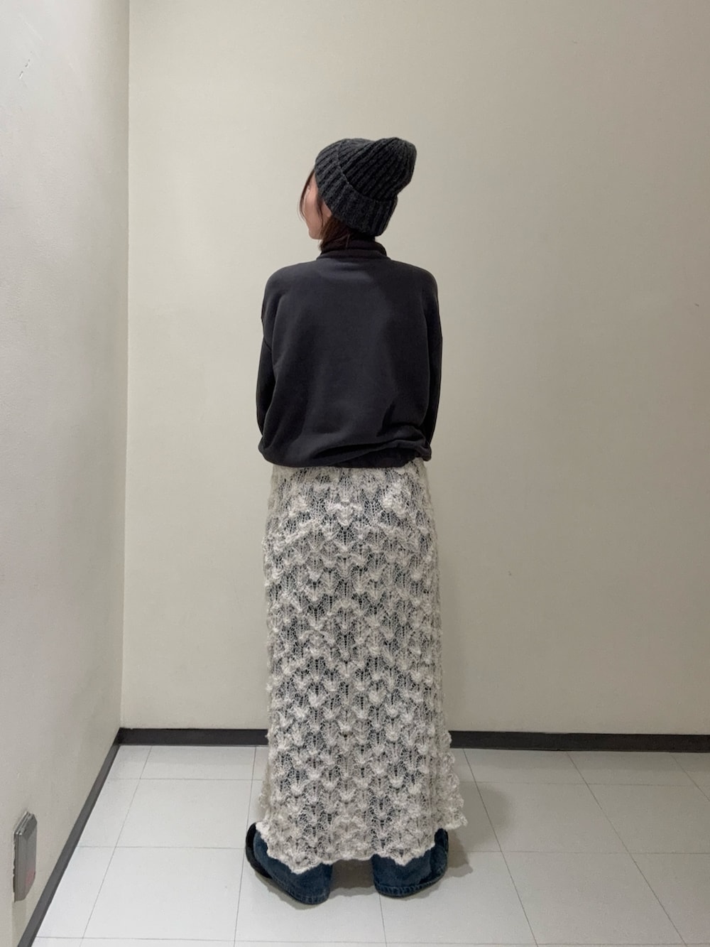 ホワイト系のスカート、グレー系のデニムパンツ、ブラック系のその他シューズを着用したレディースの秋コーディネートの4枚目の写真