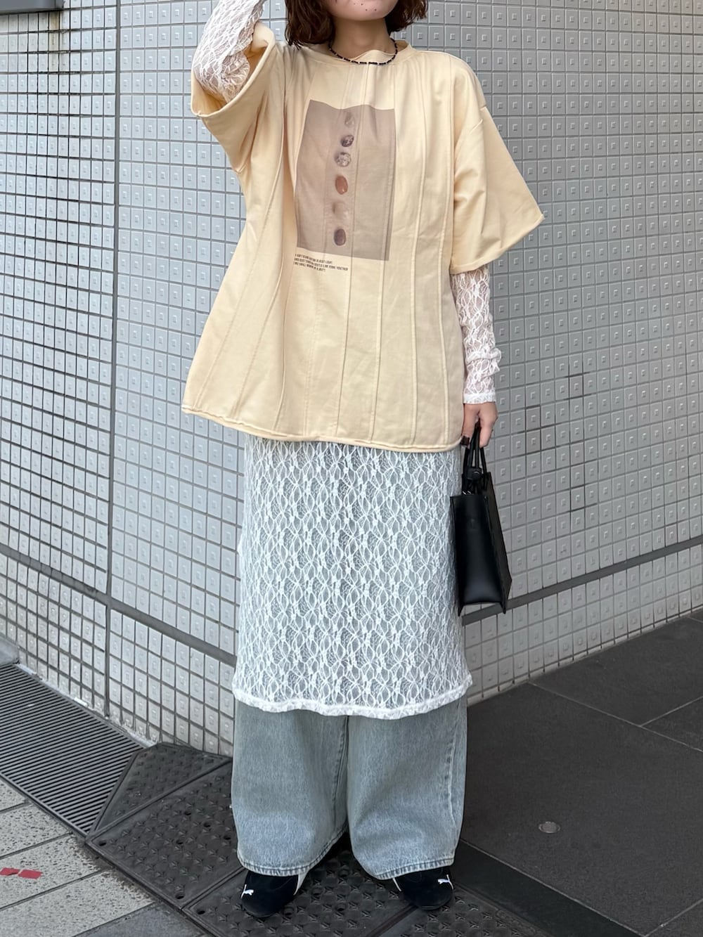 ホワイト系のワンピース、イエロー系のTシャツ/カットソー、ブルー系のデニムパンツを着用したレディースの春コーディネートの2枚目の写真