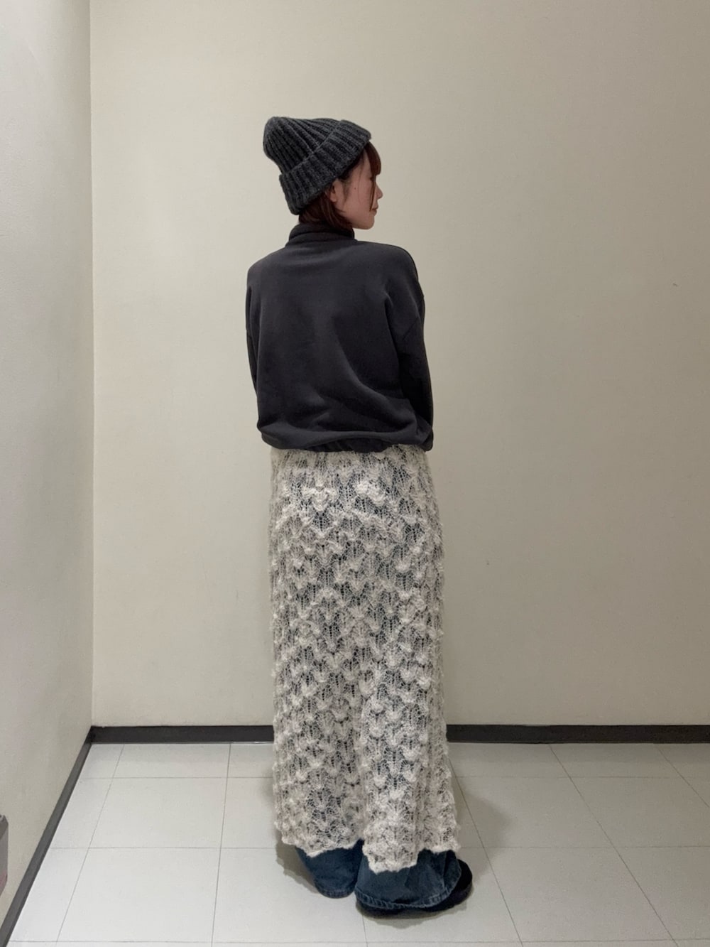 ホワイト系のスカート、グレー系のデニムパンツ、ブラック系のその他シューズを着用したレディースの秋コーディネートの3枚目の写真