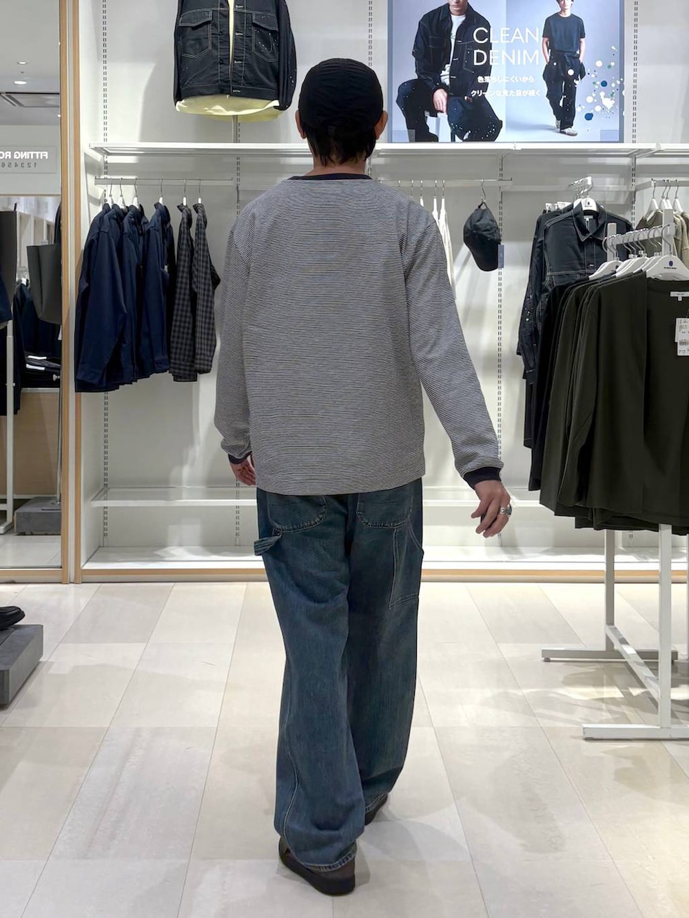 ブルー系のTシャツ/カットソー、グレー系のスニーカー、ブルー系のデニムパンツを着用したメンズの秋コーディネートの3枚目の写真