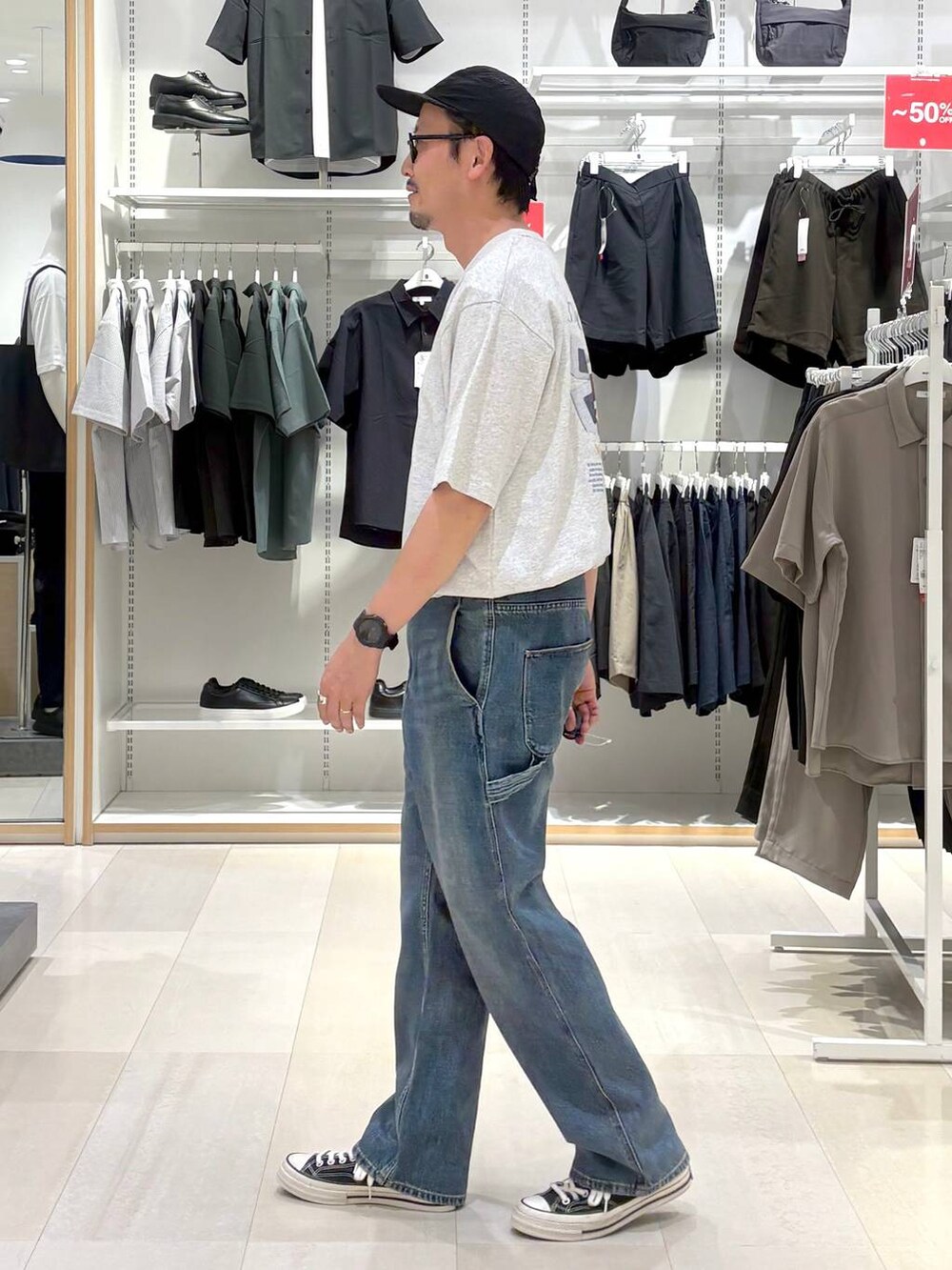 ブルー系のデニムパンツ、グレー系のTシャツ/カットソー、ブラック系のサングラスを着用したメンズの秋コーディネートの2枚目の写真