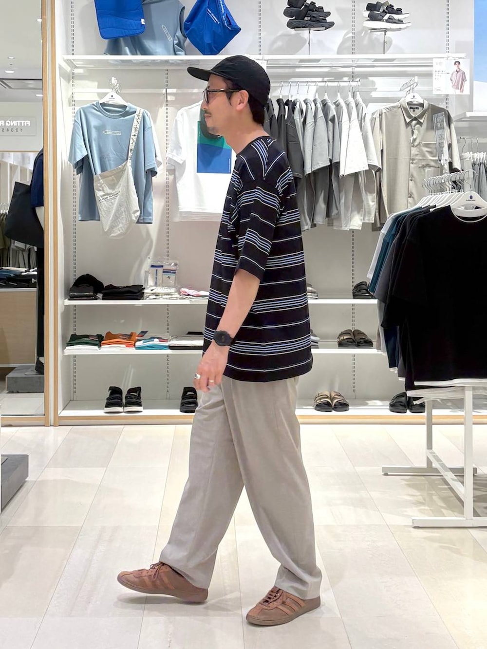 ブラウン系のスラックス、グレー系のTシャツ/カットソーを着用したメンズの夏コーディネートの2枚目の写真
