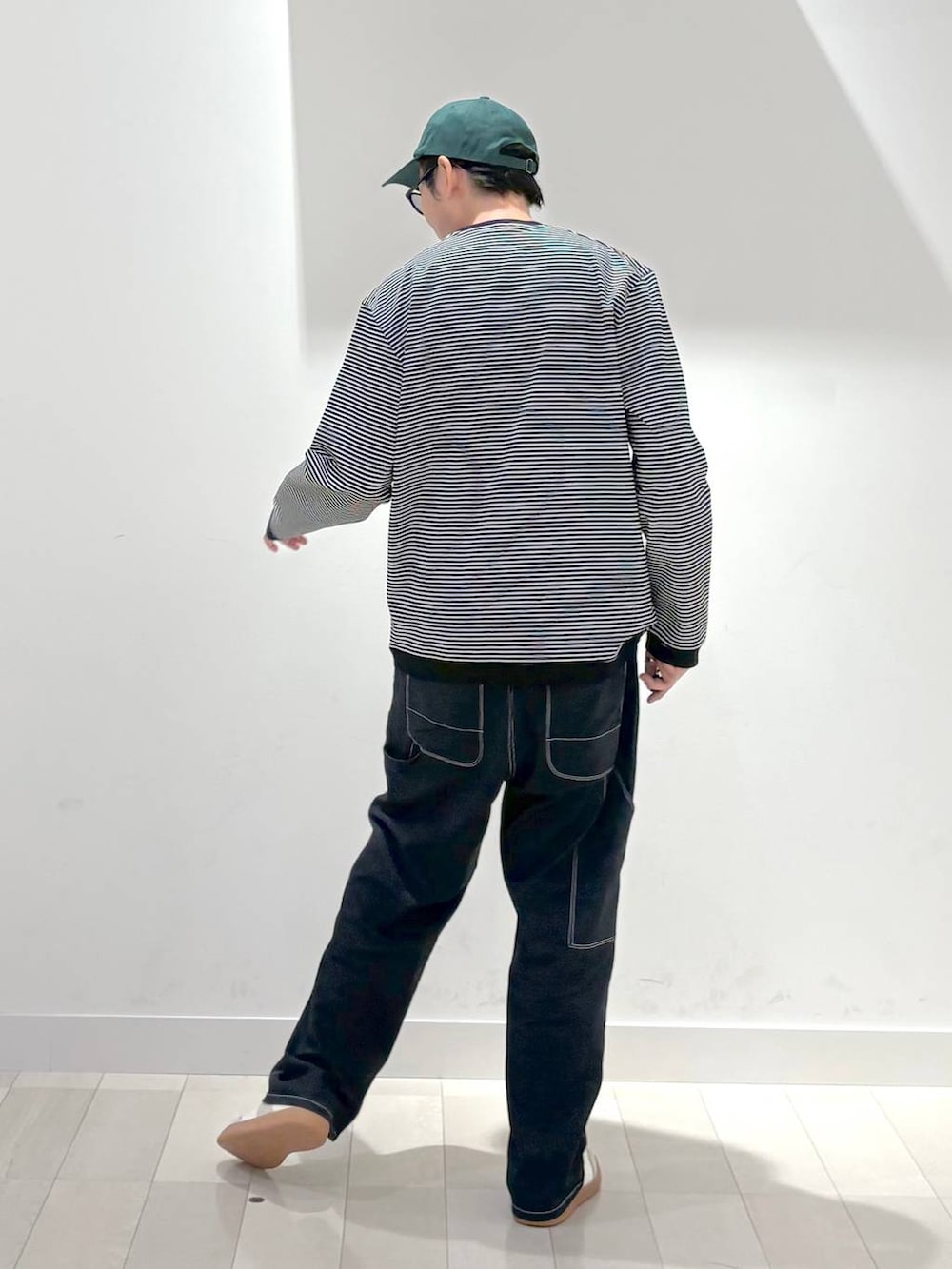 ベージュ系のスニーカー、ブルー系のデニムパンツ、ブラック系のスウェットを着用したメンズの秋コーディネートの3枚目の写真