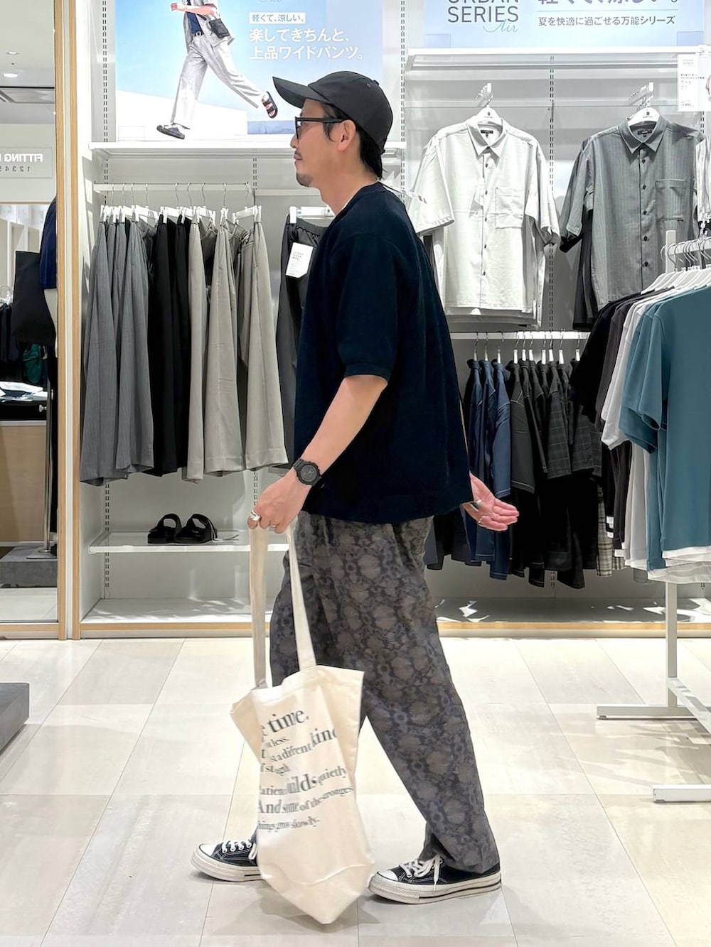 ホワイト系のトートバッグ、グレー系のその他パンツ、ブルー系のカーディガン/ボレロを着用したメンズの夏コーディネートの2枚目の写真