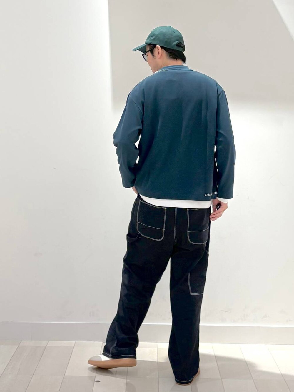 ベージュ系のスニーカー、ブルー系のデニムパンツ、グリーン系のカーディガン/ボレロを着用したメンズの秋コーディネートの3枚目の写真