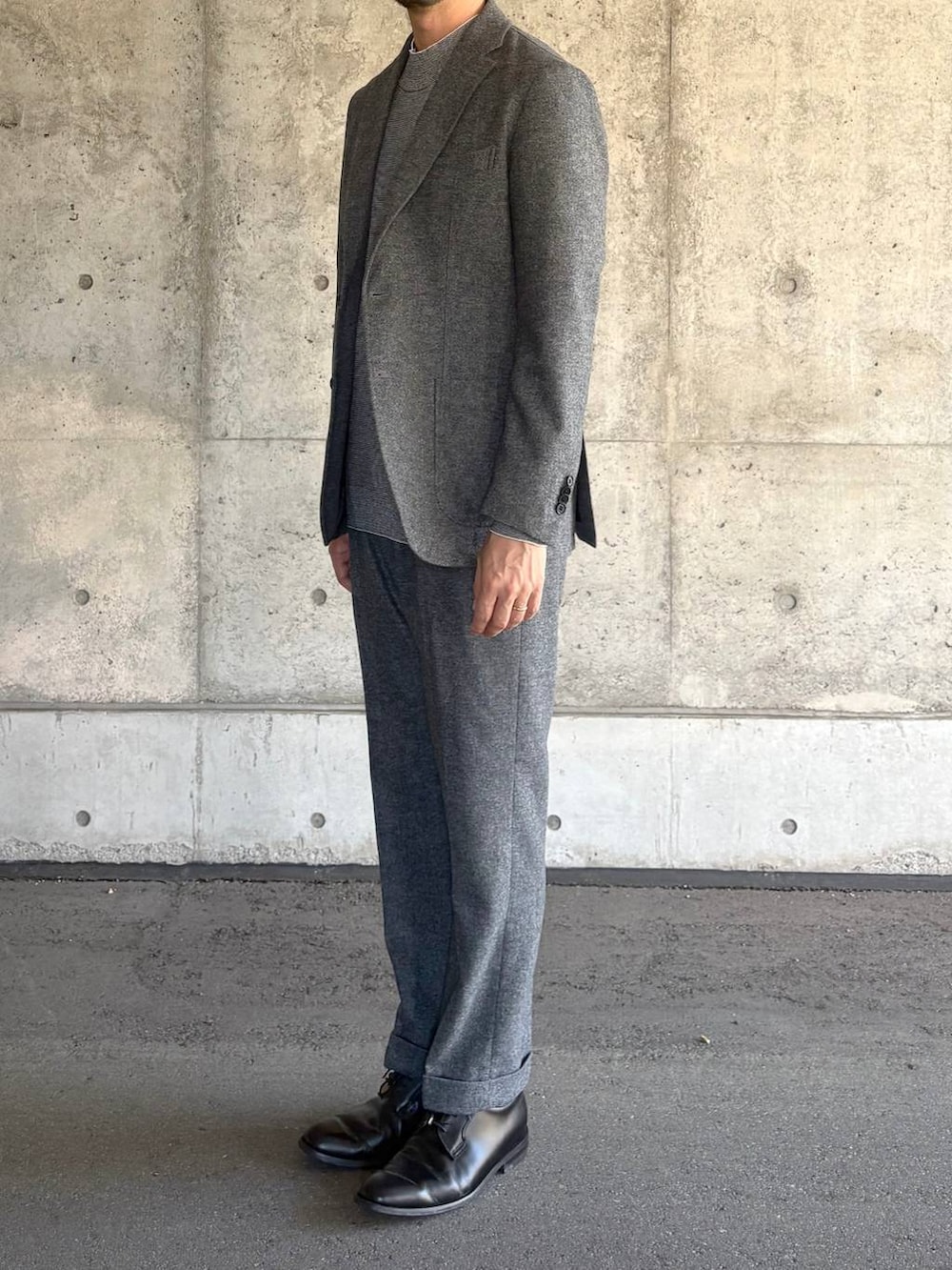 グレー系のテーラードジャケット、グレー系のスラックス、グレー系のニット/セーターを着用したメンズの秋コーディネートの3枚目の写真