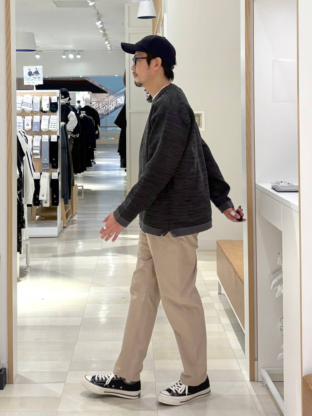 グレー系のニット/セーター、ベージュ系のその他パンツ、ブラック系のキャップを着用したメンズの秋コーディネートの2枚目の写真