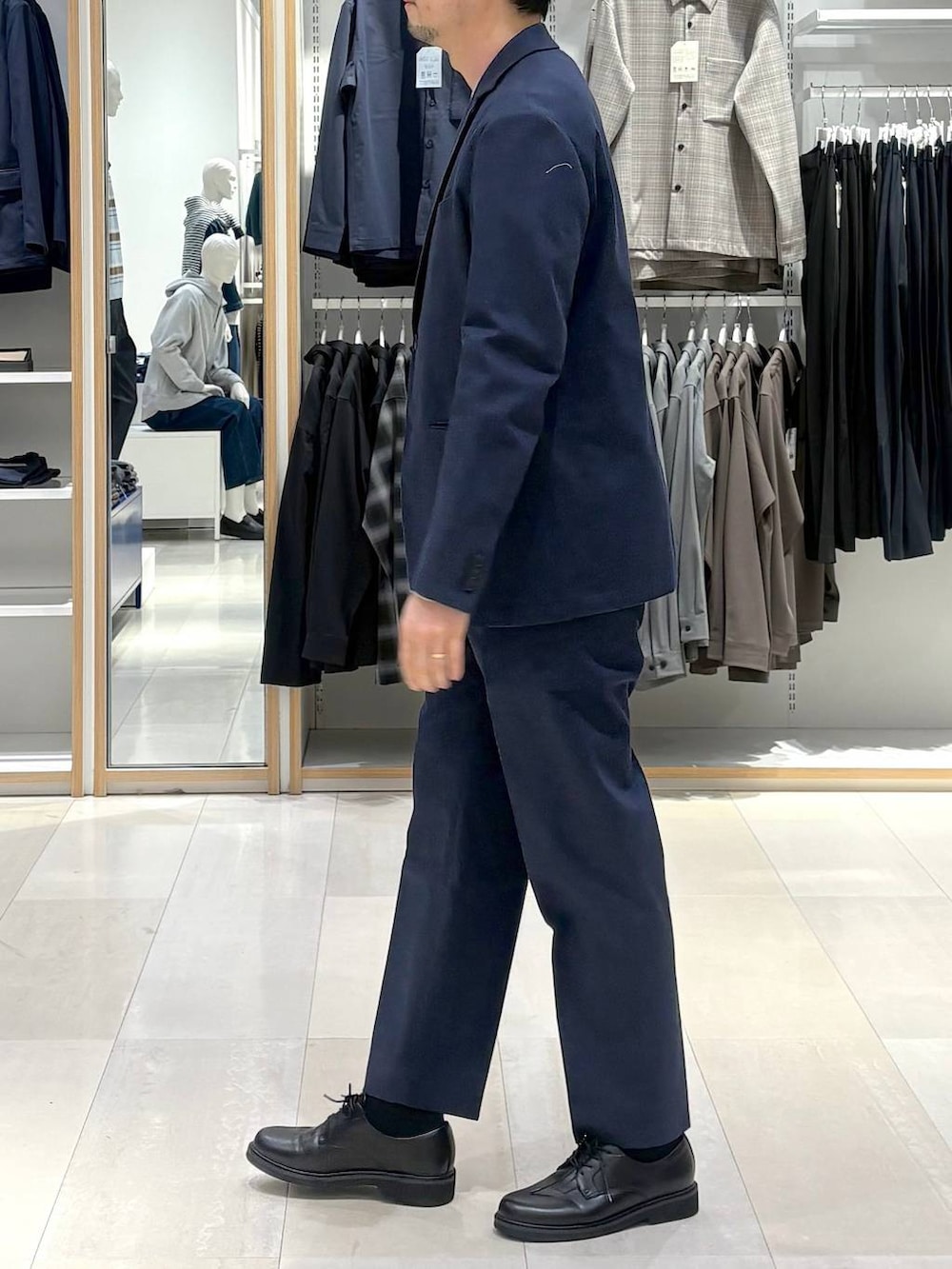 ブルー系のデニムジャケット、ブルー系のスラックス、グレー系のニット/セーターを着用したメンズの春コーディネートの2枚目の写真