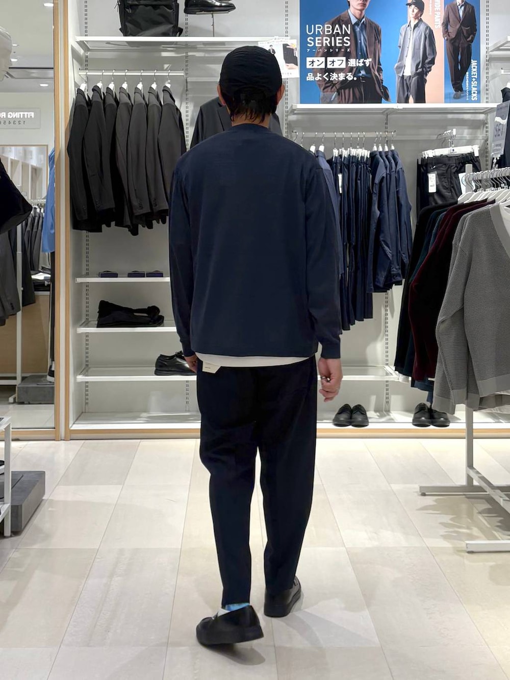 ホワイト系のTシャツ/カットソー、ブルー系のスラックス、グレー系のその他シューズを着用したメンズの秋コーディネートの3枚目の写真