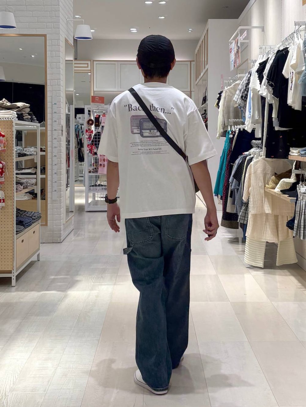 ブラウン系のショルダーバッグ、ブラック系のスニーカー、ブルー系のデニムパンツを着用したメンズの秋コーディネートの3枚目の写真