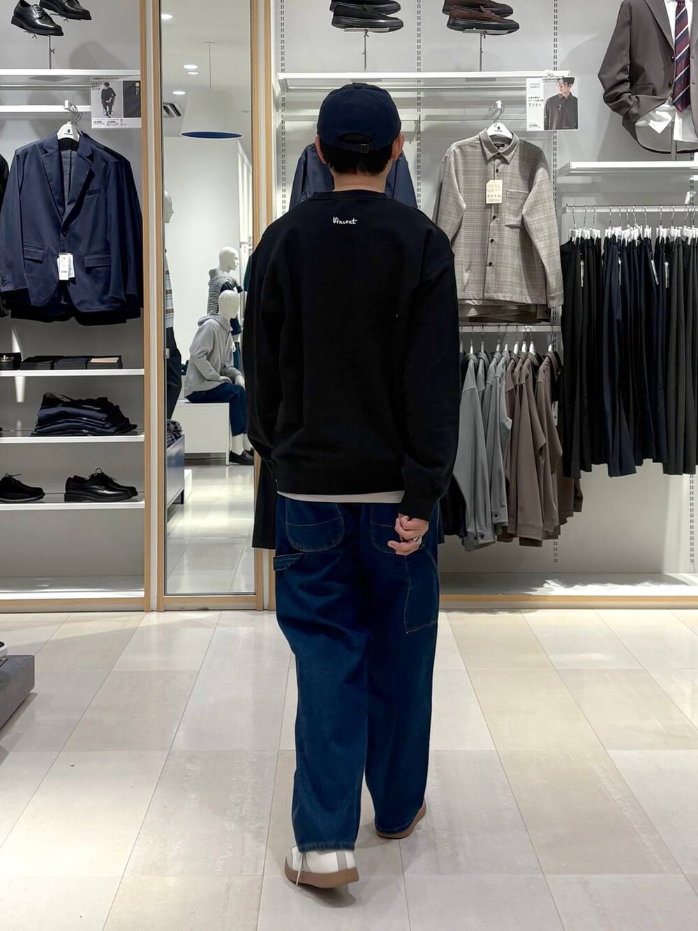 ベージュ系のスニーカー、ブラック系のスウェット、ブルー系のデニムパンツを着用したメンズの冬コーディネートの3枚目の写真