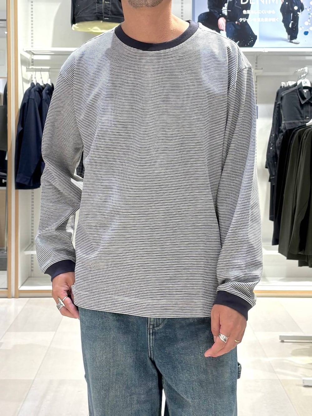 ブルー系のTシャツ/カットソー、グレー系のスニーカー、ブルー系のデニムパンツを着用したメンズの秋コーディネートの4枚目の写真