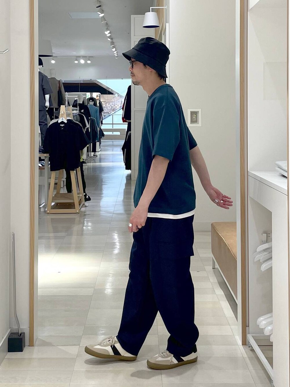 ホワイト系のスニーカー、ブルー系のカーゴパンツ、ベージュ系のスウェットを着用したメンズの夏コーディネートの2枚目の写真