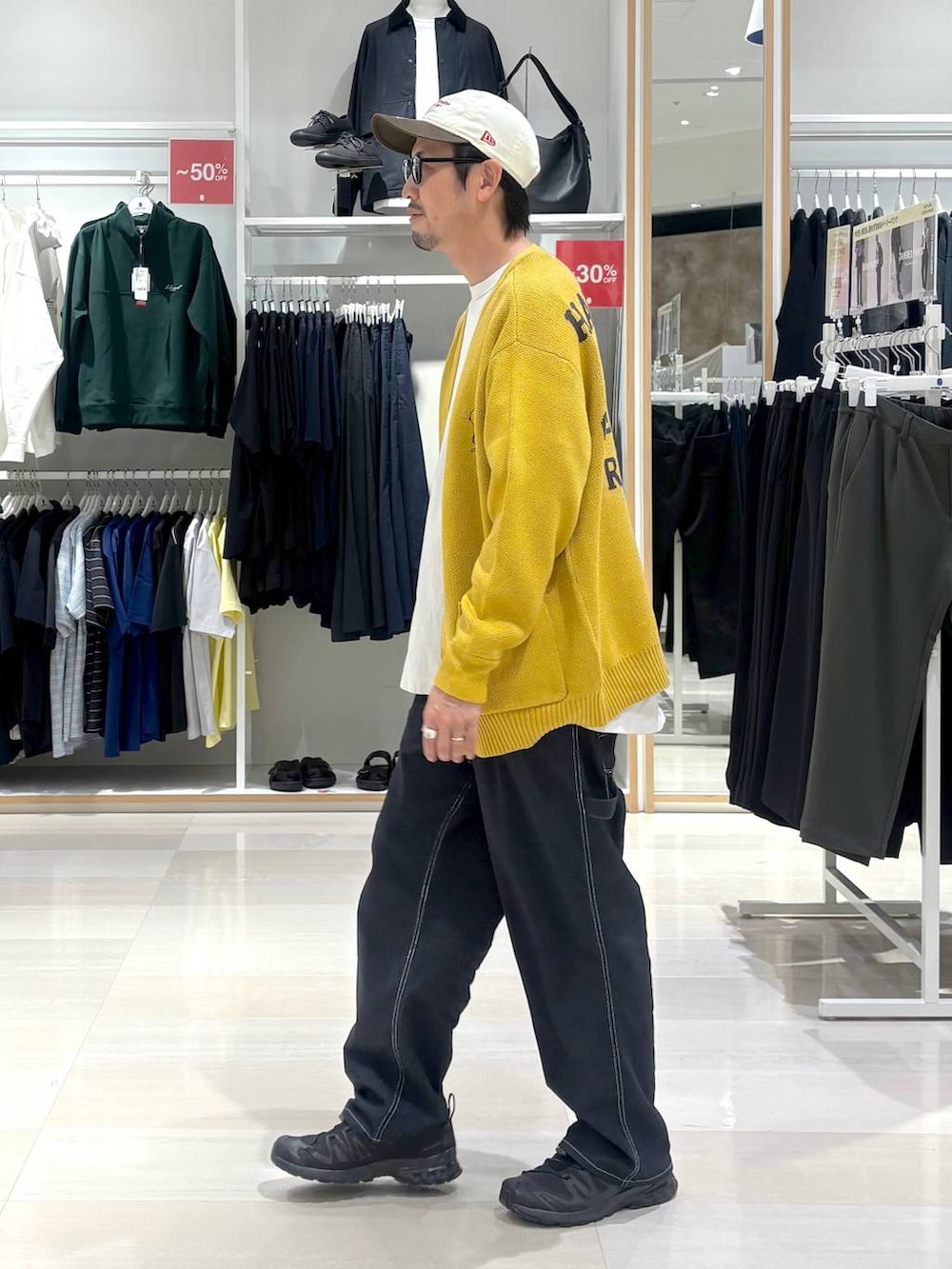 ブルー系のデニムパンツ、イエロー系のカーディガン/ボレロ、ブラック系のサングラスを着用したメンズの秋コーディネートの3枚目の写真